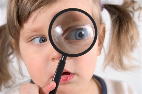 Girl searches with magnifying glass