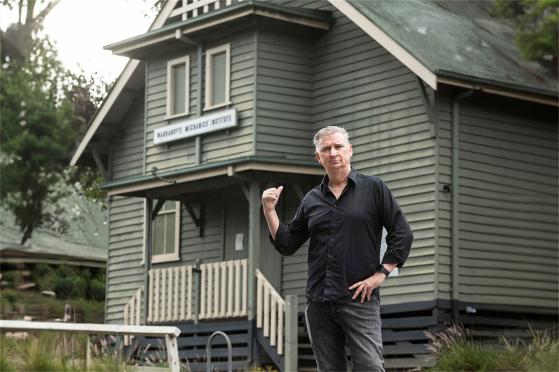A man standing in front of a town hall